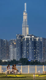 Modern buildings in city against sky at night