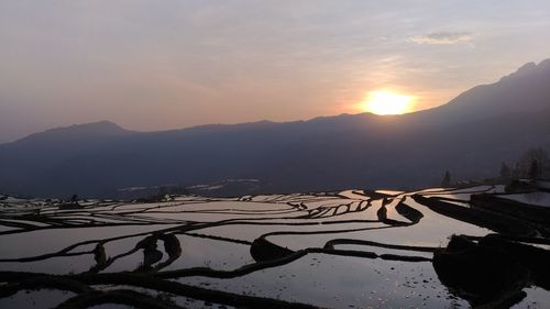 Scenic view of silhouette mountains against sky during sunset