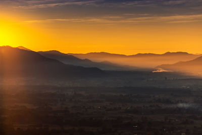 Scenic view of mountains against orange sky