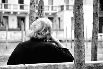 Rear view of woman sitting on bench
