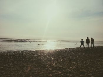 People on beach against sky