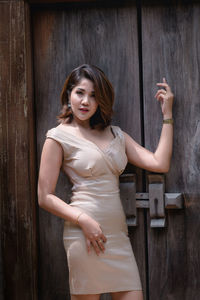 Portrait of young woman standing against entrance