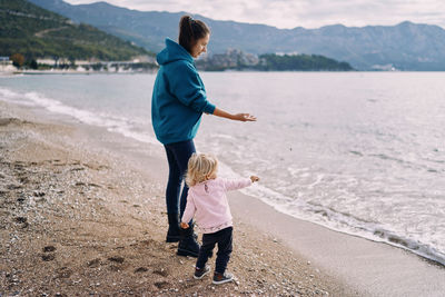 Rear view of young woman walking at beach