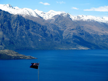 Scenic view of sea and snowcapped mountains against sky