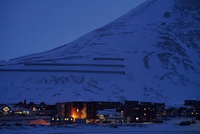 Aerial view of illuminated buildings against sky at night