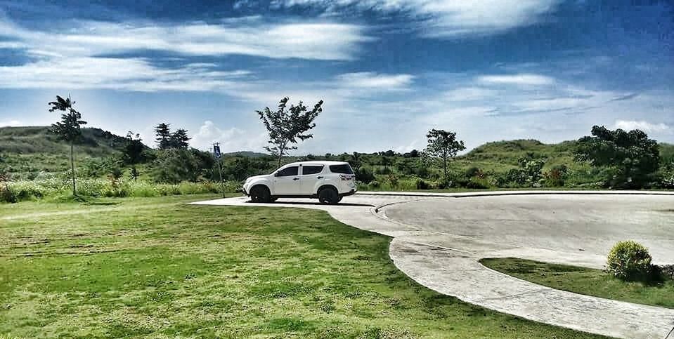 CARS ON LANDSCAPE AGAINST SKY