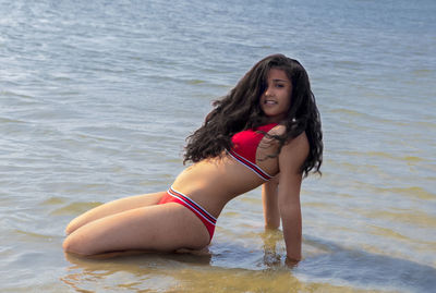 Portrait of young woman in bikini in sea