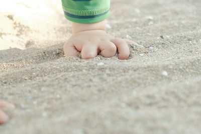 Low section of woman standing on sand