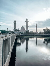 Mosque in bukit jelutong with reflection in the lake and walkway bridge