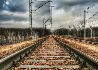 Railroad tracks against cloudy sky