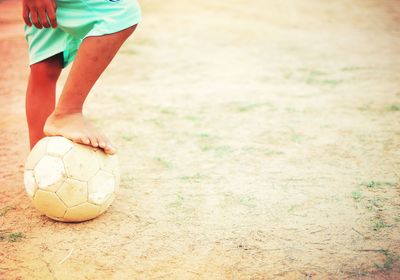 Low section of boy playing soccer ball