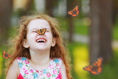 Funny laughing curly girl with a butterfly on his nose. healthy smile with white teeth.