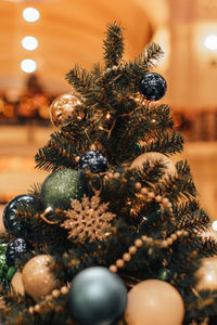 A traditional christmas tree, decorated with lights, snowflakes, beads. festive details 