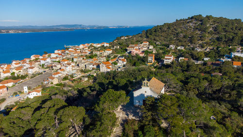 High angle view of townscape by sea against sky