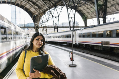 Portrait of smiling woman at railroad station