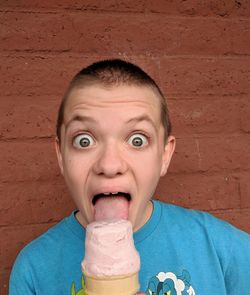 Portrait of boy with ice cream against wall