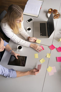 High angle view of coworkers sitting at meeting table