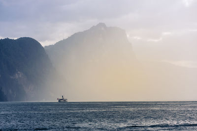 Boat sailing on sea against sky during sunset