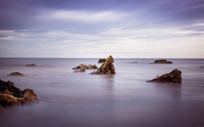 Scenic view of sea against cloudy sky