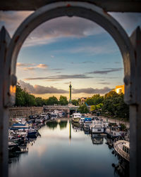 Bridge over river in city against sky during sunset