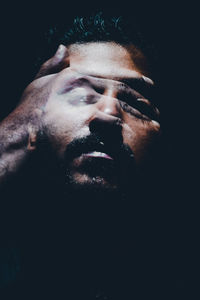 Close-up of man against black background