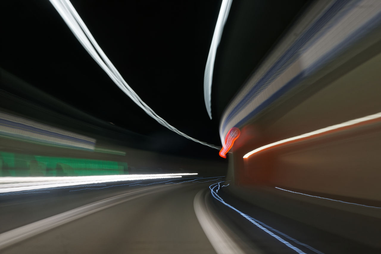 LIGHT TRAILS ON ROAD SEEN THROUGH WINDSHIELD