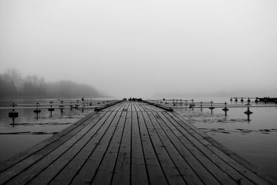 Pier over lake against clear sky