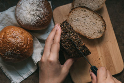 Close-up of hand cutting bread