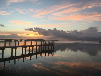 Pier on sea against sky during sunset