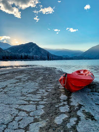 Red floating on lake against sky during winter