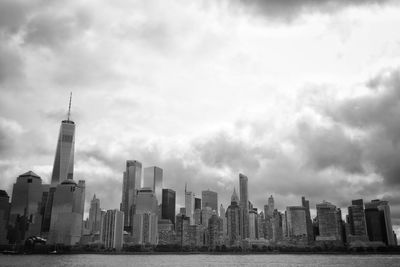 Buildings in city against cloudy sky