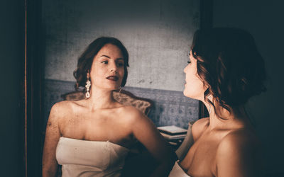 Close-up of young woman with reflection in mirror