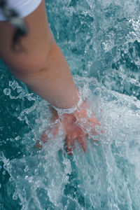 Cropped hand splashing water