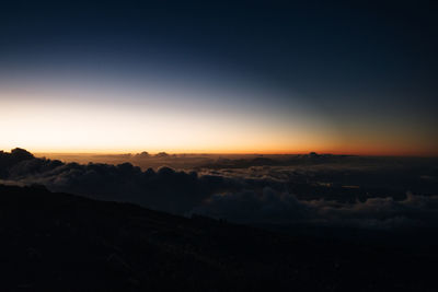 Scenic view of mountains against clear sky during sunset