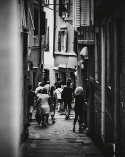 Rear view of people walking on street in city