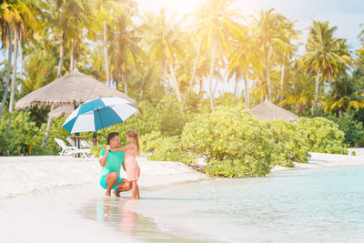 People on beach against trees