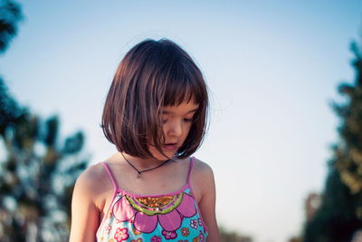Portrait of a girl looking away against sky