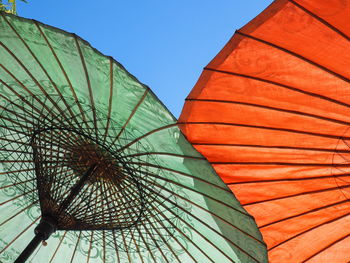 Low angle view of parasols against clear sky