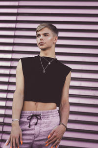 Portrait of teenage girl standing against wall