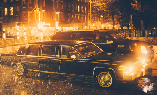 Illuminated cars on street during rainy season at night