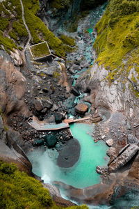 High angle view of stream amidst rocks in sea