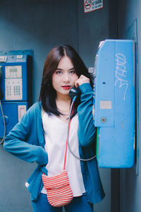 Portrait of young woman talking over telephone