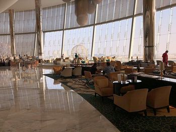 Chairs and tables by window at airport