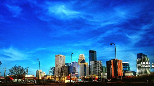 Low angle view of modern buildings against cloudy sky