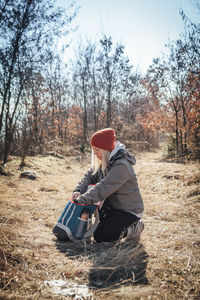 Side view of man sitting on field