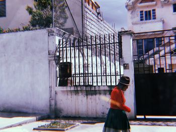 Side view of man standing on street against buildings