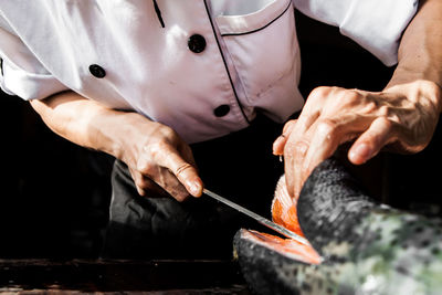 Midsection of chef cutting food