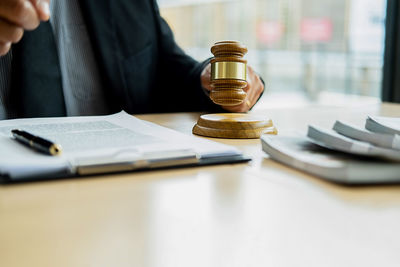 Midsection of man reading book on table