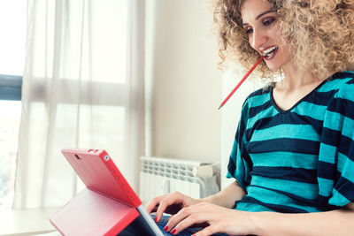 Midsection of woman using mobile phone at home