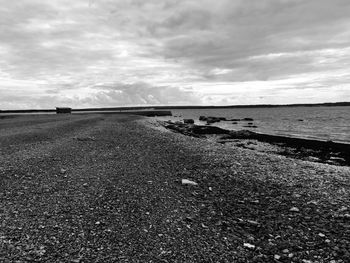 Scenic view of beach against cloudy sky